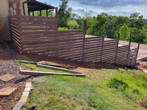 Brown Balau 1x6 hardwood privacy fence installed on sloped landscape in Dahlonega Georgia