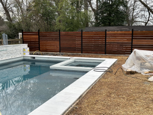 Brown Balau hardwood privacy fence installed with track system featuring horizontal boards and rich natural tones