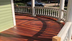 Cumaru 3.5 inch tongue and groove porch decking installed on curved wraparound porch with herringbone pattern and rich Brazilian hardwood tones