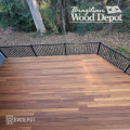 Cumaru hardwood deck with varied red, brown, and amber tones installed in a forested backyard setting.