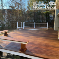 Multi-level Cumaru hardwood deck with warm red-brown tones overlooking a wooded backyard.