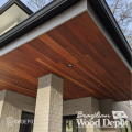 Cumaru tongue and groove ceiling installation on a covered exterior entryway with warm brown tones.