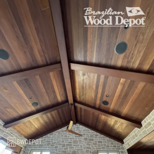 Brown Balau Tongue and Groove Ceiling Installation – Exterior Hardwood Soffit Brown Balau tongue and groove hardwood ceiling installed in an outdoor covered patio with exposed beams and recessed lighting.
