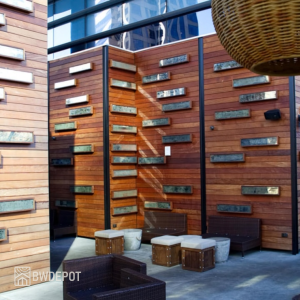 Outdoor courtyard clad in horizontal Ipe siding with decorative metal accents mounted to the wall and modern seating below.