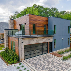 Modern two-story home with horizontal Ipe RainScreen siding, glass balcony railing, and contemporary garage door.