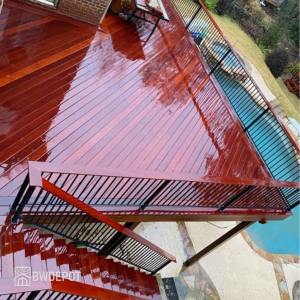 Freshly oiled Massaranduba decking 1x6 boards with water on the surface highlighting deep brick-red tones.