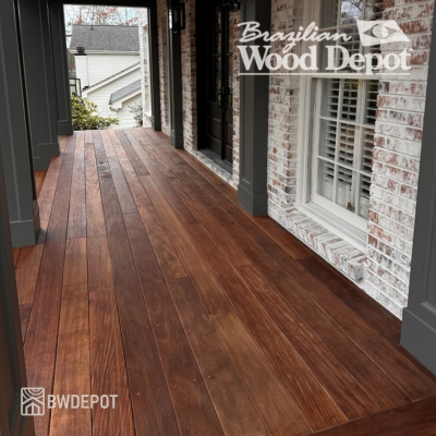 Brown Balau hardwood decking installed on a covered porch alongside brick exterior walls.