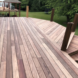 Purpleheart decking boards showing advanced weathering with muted brown and gray tones and pronounced grain lines.