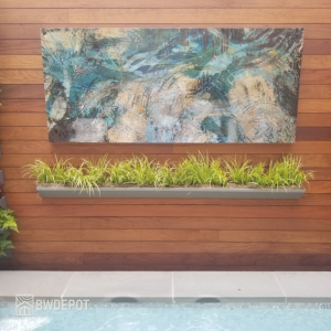 Horizontal Ipe RainScreen siding installed on an exterior wall with a large abstract art panel and linear planter beneath it near a pool area.