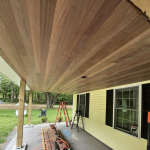 Brown Balau tongue and groove porch ceiling before maintenance oil, showing the natural weathered appearance of the hardwood.