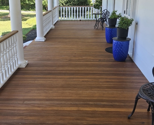 Long covered porch finished with 3.5 inch Brown Balau tongue and groove hardwood decking from BWDepot.com